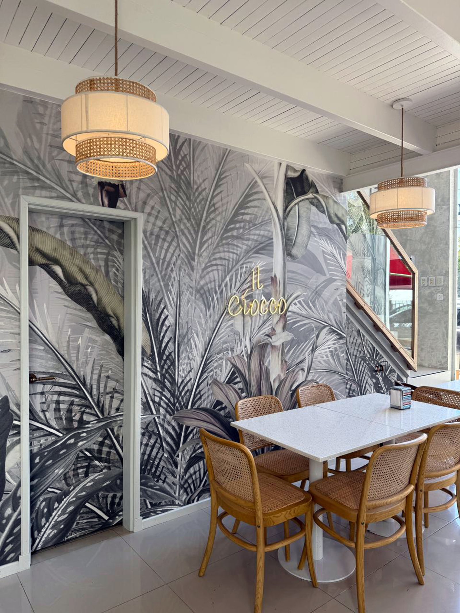 Comedor con mural tropical, luces de mimbre y sillas de rattan — proyecto Heladeria il ciocco, por Alchemyst artisan studio, en Pehuajó